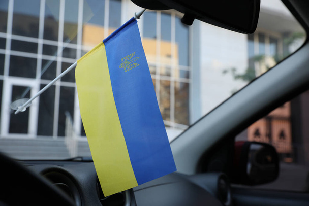 National flag of Ukraine on windshield inside car - Foto, afbeelding