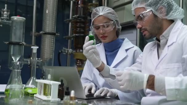 Kimyasal ve biyomedikal deneyler için tedavi laboratuvarında çalışan profesyonel üniformalı iki bilim adamı. - Video, Çekim