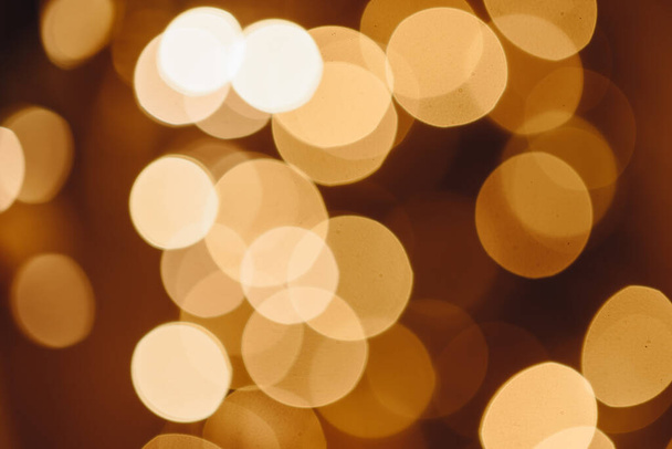 Circles of Bright Lights in in Dark. Black Background with Golden Light Effects. Horizontal Background with Blur Bokeh Effects for Christmas. Special Occasion Concept with Place for Text. - Foto, afbeelding