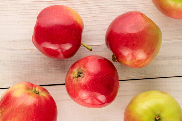 Several juicy red apples on a wooden table, macro, top view. - 写真・画像