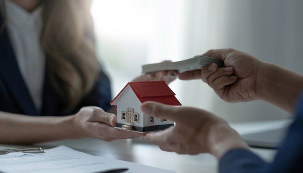A professional female real estate agent receives a house loan payment or rent fee from her client. Property investment concept. cropped imag - Foto, immagini