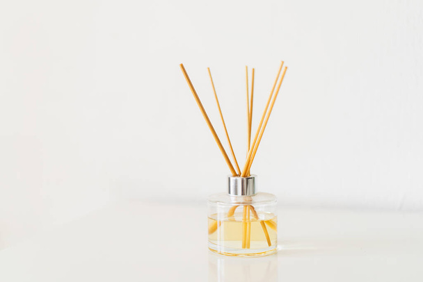 Spa therapy, aromatherapy. Diffuser bottle on a white background. Incense sticks for the home with a floral scent. The concept of eco-friendly fragrance for the home - Photo, image