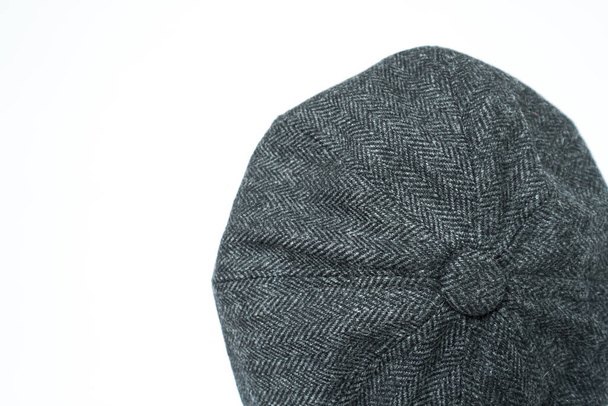 Detail of a classic eight-panel newsboy hat in black base, in herringbone wool fabric set on a bronze head mannequin on a white background - Valokuva, kuva