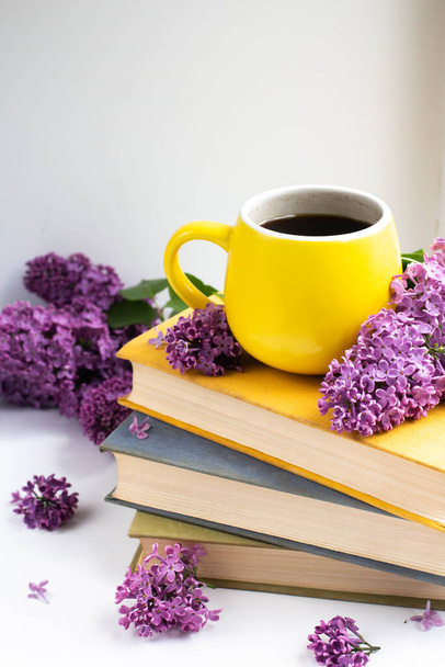 cup with cofee with lilac flowers and books. mug and lilac - Foto, Imagem