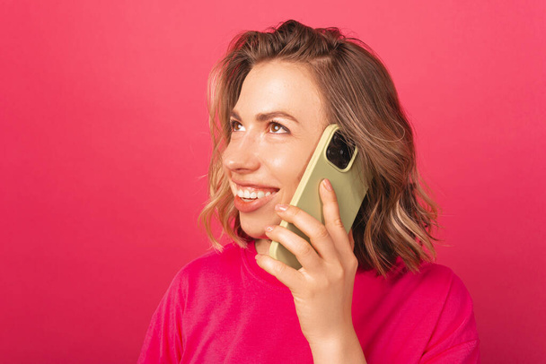 Ein Nahaufnahme-Foto einer fröhlichen jungen Frau, die am Telefon spricht - Foto, Bild