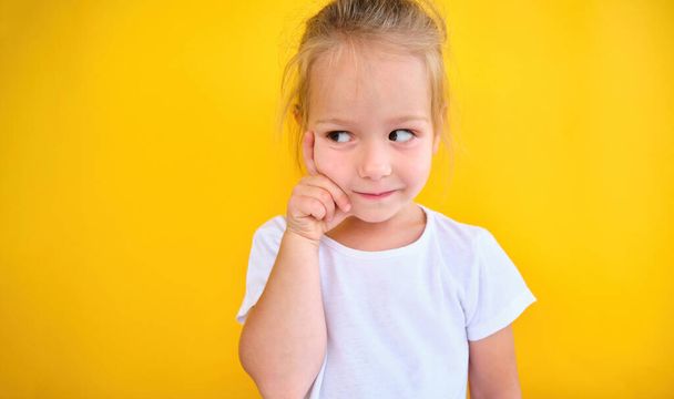 Muotokuva onnellinen pieni tyttö lapsi ajattelu haaveilee etsivät pois monia ideoita eristetty sininen seinä tausta. Laadukas kuva - Valokuva, kuva