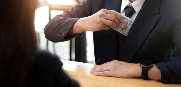 A businessman take a dollar money banknote into his suit pocket. Corruption and bribery concept. cropped imag - Foto, Imagem