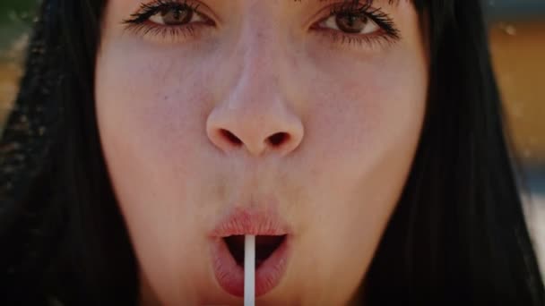 playful girl sexually licks a lollipop on the street. enjoying summer in Ukraine. close-up. - Πλάνα, βίντεο