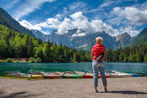Blonde Frau bewundert einen schönen Bergsee - Foto, Bild