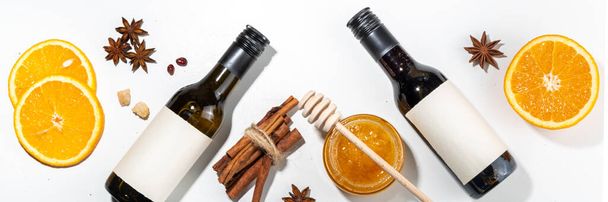 Different mulled wine ingredients set on white background, flat lay with wine bottle, cinnamon, apple, orange, anise star, simple autumn food drink cooking background - Fotoğraf, Görsel