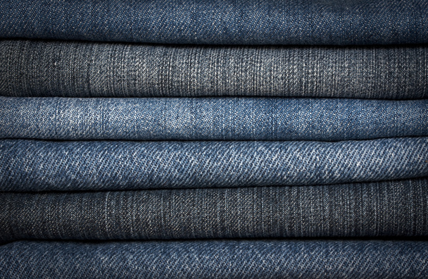 A pile of different types of blue denim jeans closeup - Photo, Image
