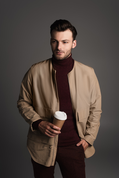 Stylish man in autumn outfit holding coffee to go isolated on grey  - Valokuva, kuva