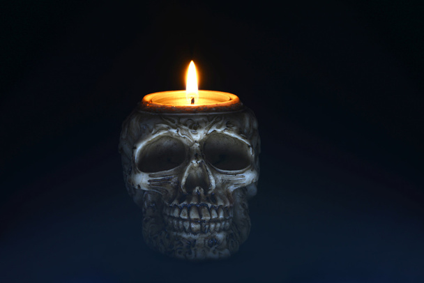 Жуткая свеча черепа на черном фоне - спереди
 - Фото, изображение