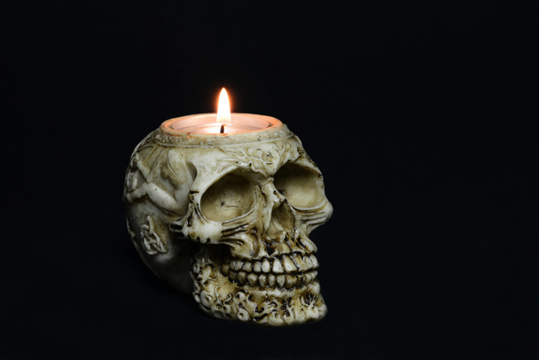 Creepy skull candle on black background - half turn - Fotó, kép