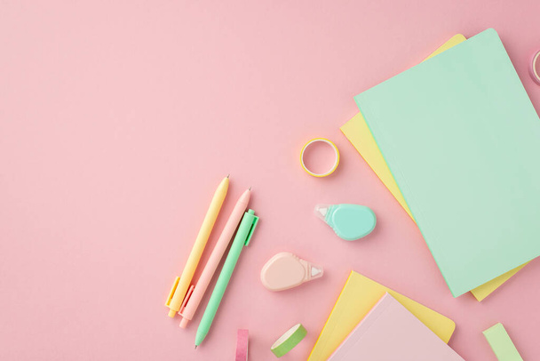 Back to school concept. Top view photo of colorful stationery diaries pens round correction tape ruler and adhesive tape on isolated pink background - Foto, afbeelding