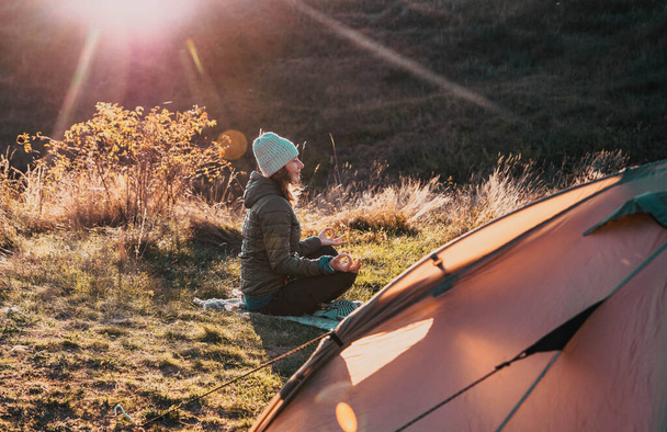 femme méditant près de tente en automne - Photo, image