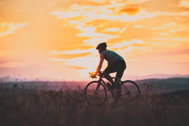 Günbatımı spor ve spor konseptinde bisikletçi silueti - Fotoğraf, Görsel