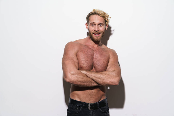 Shirtless blonde man smiling posing with arms crossed isolated over white background - Fotó, kép
