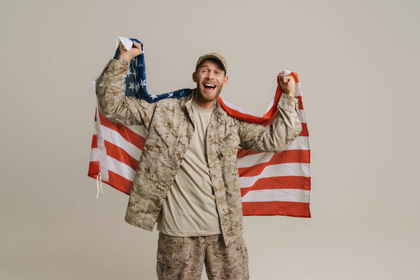 White military man screaming while posing with american flag isolated over white wall - Foto, Imagen