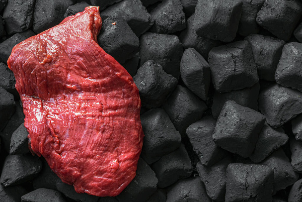 Top view raw fresh beef meat over a charcoal with copy space - Photo, image