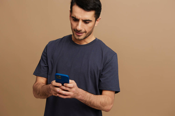 Homem alegre smartphone posando moda auto-confiança isolado fundo. Foto de alta qualidade - Foto, Imagem