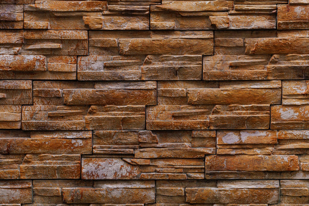 Textured rough surface of decorative natural stone wall. Background or backdrop. A blank for design or a graphic resource for a designer. Exterior decoration of buildings - Foto, Imagen