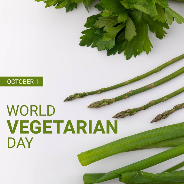 Composition of world vegetarian day text over green vegetables on white background. World vegetarian day and celebration concept digitally generated image. - Foto, Imagem
