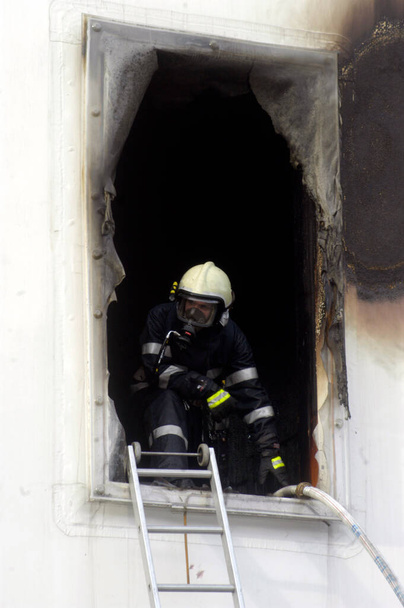 пожарный в защитной одежде и респираторной маске против дымового газа - Фото, изображение