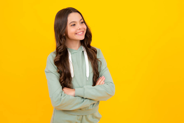 Teenager girl crossed arms isolated on yellow background. Studio portrait of child with mock up copy space - Foto, immagini
