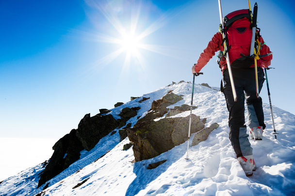 Climberr περπατώντας μια απότομη χιονισμένη κορυφογραμμή με τα σκι στην t - Φωτογραφία, εικόνα