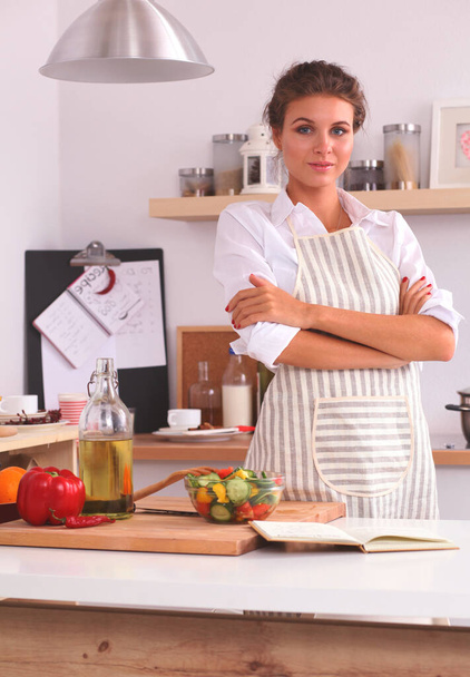 Smiling woman in the kitchen, isolated on christmas background - Foto, Imagen