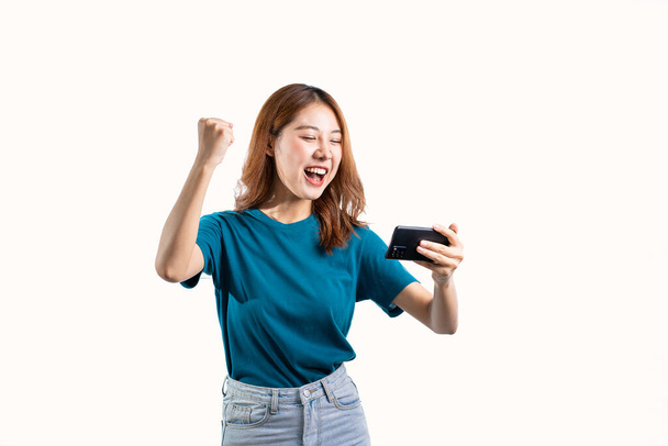 Cute Asian woman holding a cell phone and gesturing isolated on white background. - Fotoğraf, Görsel