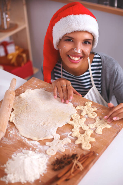 Christmas baking santa woman smiling happy having fun with Christmas preparations wearing Santa hat - Foto, Imagen