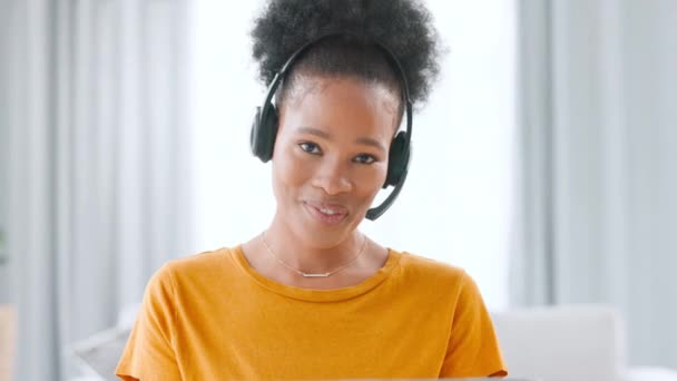 Happy, smiling and confident call center agent with a headset working remotely at home. Portrait of a friendly, helpful and cheerful freelance consultant helping customers with service and support. - Materiał filmowy, wideo