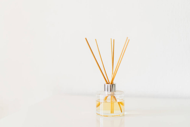 Spa therapy, aromatherapy. Diffuser bottle on a white background. Incense sticks for the home with a floral scent. The concept of eco-friendly fragrance for the home - Фото, изображение