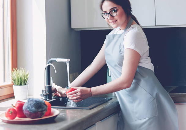 Hands of woman washing vegetables at her kitchen. - Foto, Bild