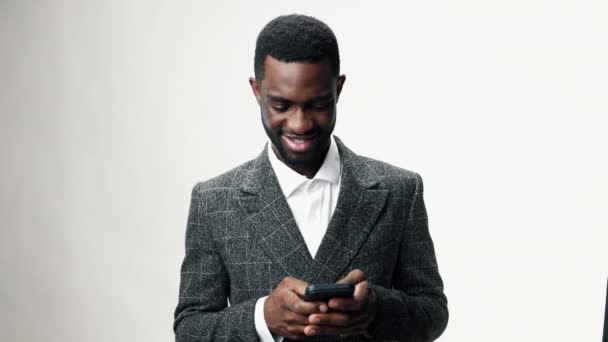 アフリカ系アメリカ人男性が携帯電話を持ち,笑顔で若いビジネスマン. 高品質の4k映像 - 映像、動画