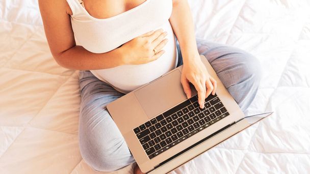 Terhességi számítógépes alkalmazás. Terhes nő digitális laptoppal. Mobil terhesség online anyasági notebook alkalmazás. Fogantatás anyaság, terhesség, szülés - Fotó, kép