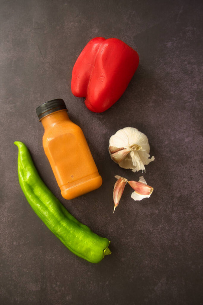 Andaluzyjskie gazpacho serwowane w plastikowej butelce. Odbierz. Pomidor, pieprz i świeża zupa warzywna na ciemnym tle. Miejsce do kopiowania i wstawiania tekstu na etykiecie. - Zdjęcie, obraz