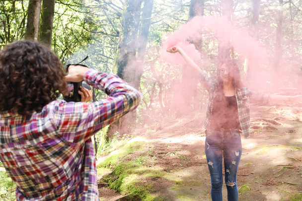 Profesjonalny fotograf robiący zdjęcia modelce w lesie trzymającej bombę dymną na Kostaryce. Wysokiej jakości zdjęcie - Zdjęcie, obraz