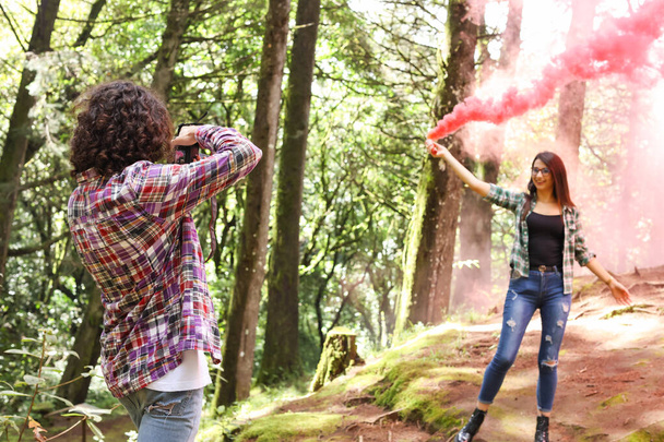 Profesional Photographer taking photographs of model in the forest holding a smoke bomb at Costa Rica. High quality photo - Photo, Image