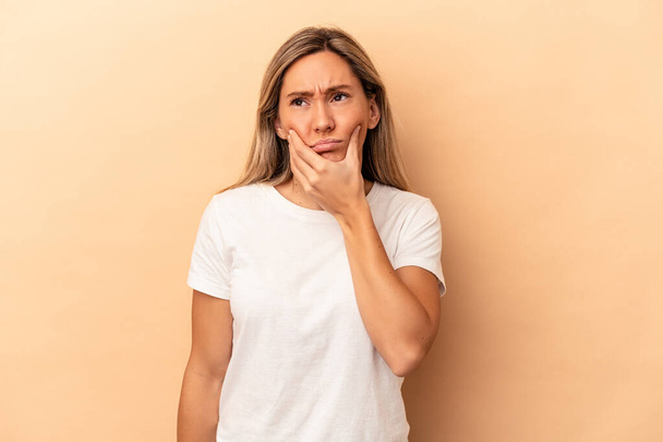 Young caucasian woman isolated on beige background having a strong teeth pain, molar ache. - Foto, Imagen