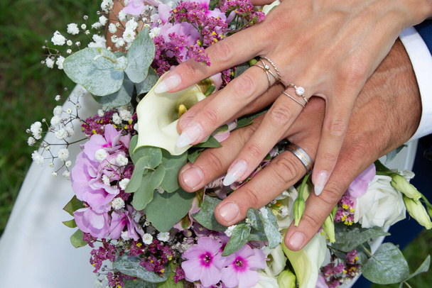Beyaz gelinlik giymiş gelin. Çiçekler ve damat. Evlilik yüzüğü altın yüzük. - Fotoğraf, Görsel