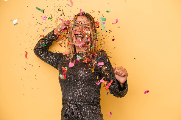 Young caucasian woman celebrating new year with confetti isolated on yellow background - Fotó, kép