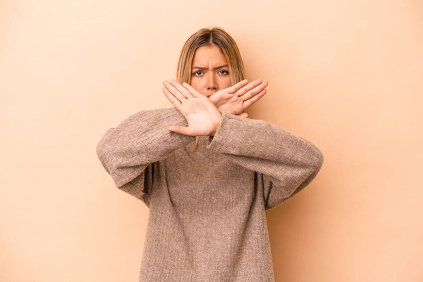 Young caucasian woman isolated on beige background doing a denial gesture - Photo, Image