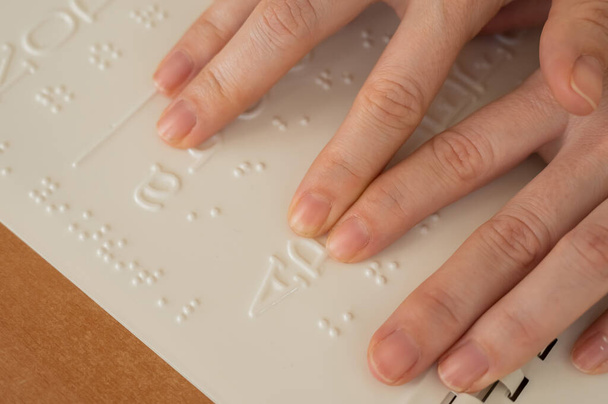 A woman learns the Braille alphabet using a decoder - Фото, зображення