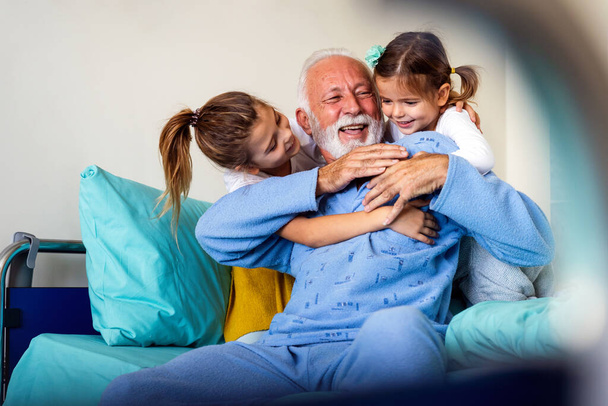 Happy children with senior grandfather laughing and enjoying leisure time together. Family, support, fun concept - Fotoğraf, Görsel