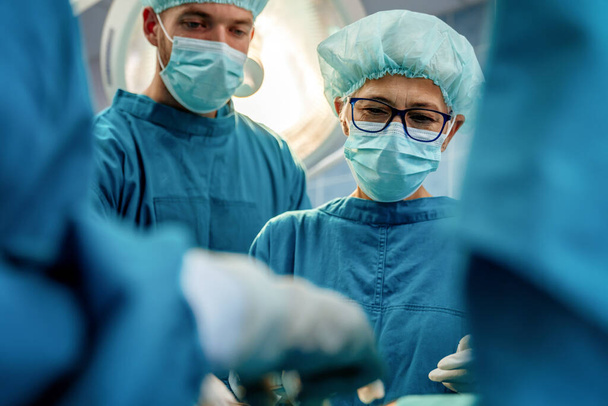 Team of surgeons in the operating room preparing for surgery in hospital - Fotoğraf, Görsel