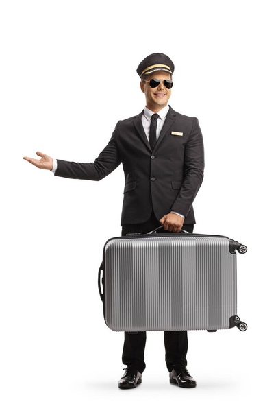 Professional chauffeur carrying a suitcase and gesturing with hand isolated on white background - 写真・画像
