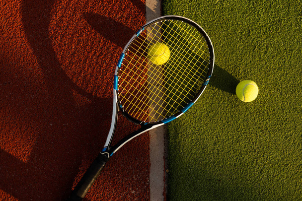 A tennis racket and new tennis ball on a freshly painted tennis court - Foto, Imagen